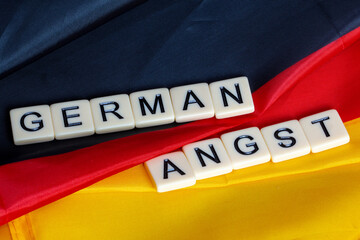 Symbolbild German Angst: Buchstabenwürfel auf einer Deutschland-Fahne
