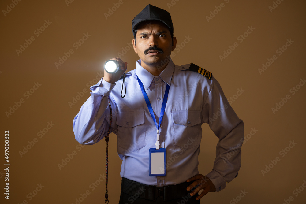 Wall mural security guard searching with torch light while working at night