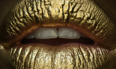 Glamour cosmetic. Gold lips, golden lipgloss on sexy lips, metallic mouth. Beauty woman makeup close up.