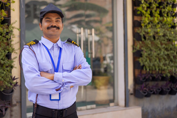 Portrait of security guard with arms folded while working at gate