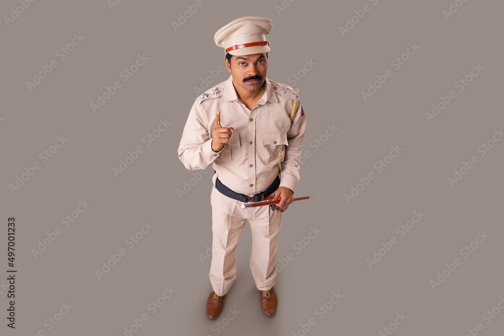 Wall mural top angle view of an indian policeman warning by pointing with index finger