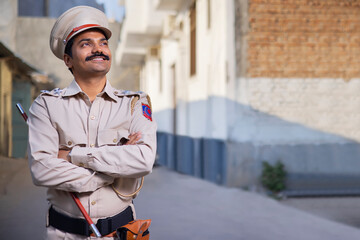 Portrait of an Indian policeman looking elsewhere with arms folded