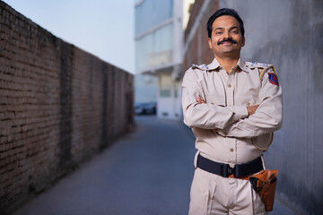 Portrait of an Indian policeman standing with arms folded