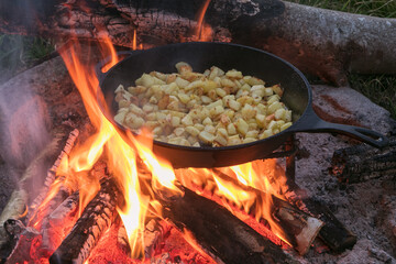 Kartoffelewürfel  in der Pfanne gebraten am offenen Feuer.