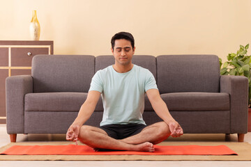 Portrait of a young man meditating at home