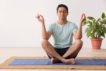 Portrait of a young man meditating at home
