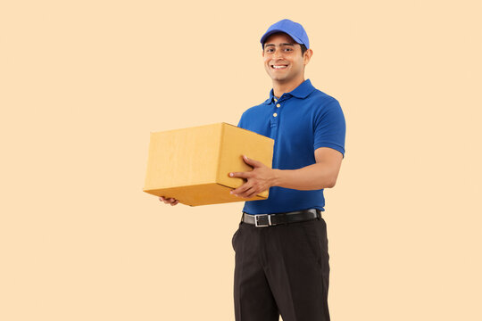 Portrait of a courier delivery boy with cardboard box in hand