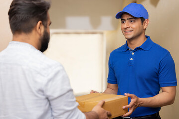 Portrait of a courier delivery boy delivering parcel to customer