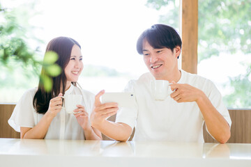 ダイニングでスマホを使う男女
