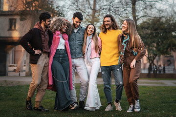multiethnic group of positive young people walking arm on shoulders in the park - diversity and...