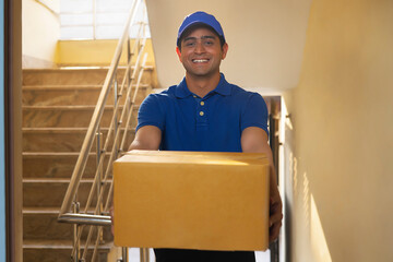 Portrait of courier delivery boy with parcels in his hand - obrazy, fototapety, plakaty
