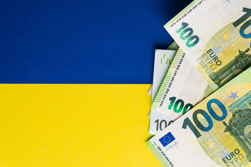 Lot of paper one hundred and fifty euro banknotes on Ukrainian flag. Top view. Money help concept