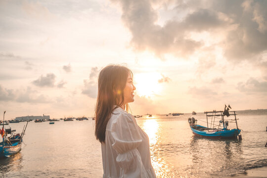 Summer Vacation. Smiling Asian women relaxing and standing, walking on the beach Vung Tau, so happy and luxury in holiday summer, outdoors cinematic sky background. Travel and lifestyle Concept.