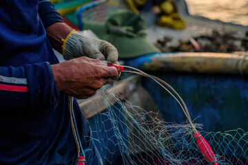 Fisherman casting his net at the sunrise or sunset. Traditional fishermen prepare the fishing net