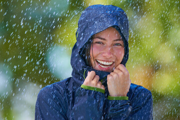 She loves the rain. Cropped shot of a young woman standing happily in the rain.