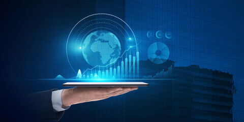 Close up of businessman hand holding pad with abstract glowing digital business chart and globe on...