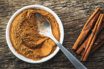Dry cinnamon sticks and cinnamon powder on wooden table. Cinnamon spice.