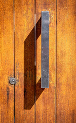 modern wooden door and metallic handle closeup, space for your text