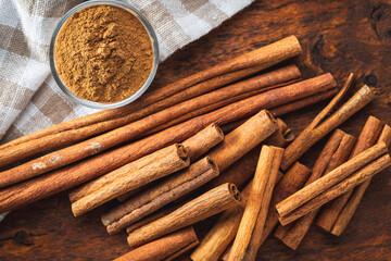 Dry cinnamon sticks and cinnamon powder on wooden table. Cinnamon spice.
