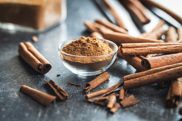 Dry cinnamon sticks and cinnamon powder on kitchen table. Cinnamon spice.
