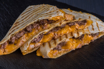 Quesadilla with beef. Tortilla, beef, cheese, white onion, cheese sauce.