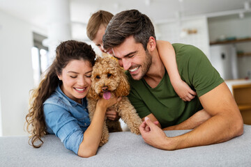 Happy family playing, having fun with dog at home