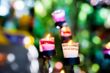 The candle is lit in a glass with a blurred background.