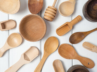 Still life of household kitchen utensils on a white wooden table. Top view, wooden cutlery