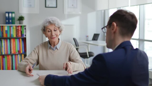 Happy elderly woman take contract and pay insurance fee with credit card