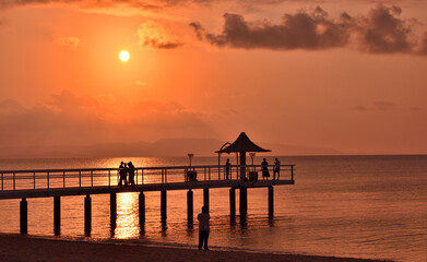 Fototapeta na wymiar 沖縄の夕焼けに照らされる海と橋