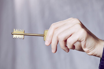  Close up of human hand holding golden key