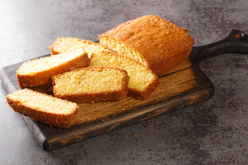 Delicious tender Madeira biscuit cake close-up on a wooden board on the table. horizontal