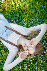 A young woman lies on the grass in flowers. High quality photo