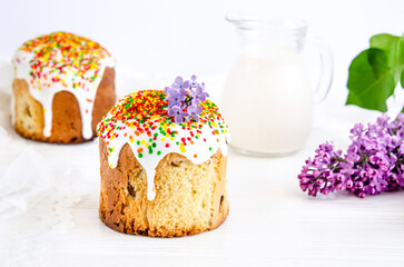 Easter cake decorated with white sugar icing and colored confectionery dragees with a bouquet of...