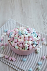 Obraz premium Rainbow Fruity Mini Marshmallows in a Pink Bowl, side view. Copy space.