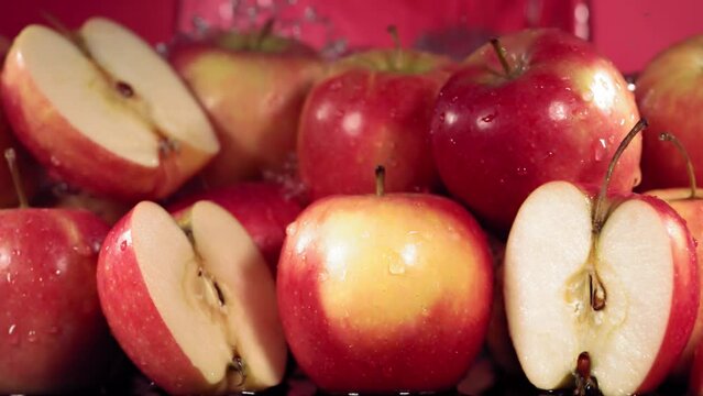 Slow Motion Shot of Red Apple Water Splashing through Apple Slices