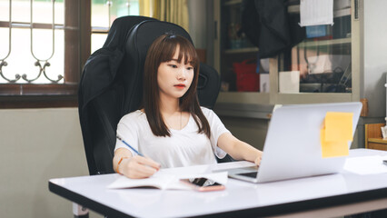 Young adult asian student woman learning at home indoor on day.