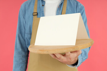 Waiter man holds tray with space for text on pink background