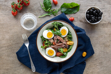 Nicoise french composed salad with canned tuna, anchovy, hard-boiled eggs, tomatoes, and black...