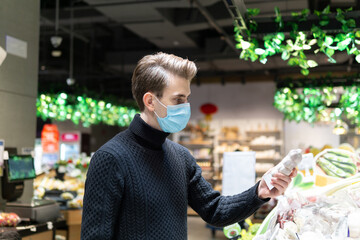 Caucasian man in supermarket wearing protective medical mask during Coronavirus, Covid-19 outbreak.	