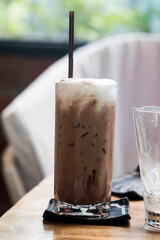 Iced mocha coffee with milk in glass on the wooden table