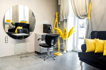 Modern small bright hair and beauty salon in black and yellow colors with gray walls and floor and...