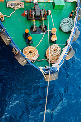 Front of the transport ship on the water, top view. The bow of the ship with an anchor winch, ropes...