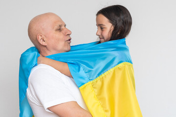 elderly man and girl with the flag of Ukraine