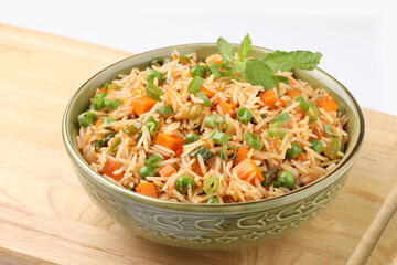 Schezwan Fried Rice is a popular indo-chinese food served in a plate or bowl with authentic sausages. selective focus
