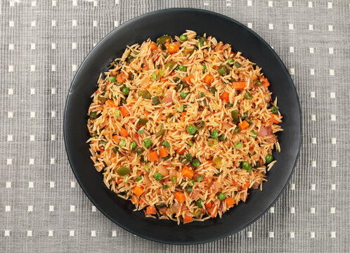 Schezwan Fried Rice is a popular indo-chinese food served in a plate or bowl with authentic sausages. selective focus