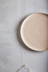 Empty plate on light rust textured background. Copy space.