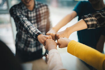 diverse group of asian business partner fist bump in modern office. Colleague partnership teamwork, university student, congratulation event, job or mission accomplish concept - obrazy, fototapety, plakaty
