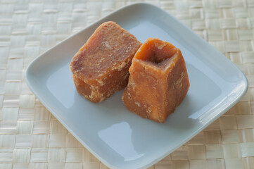 Sugarcane concentrate - an Indian jaggery cakes on white plate