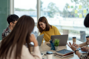 Young Asian woman leading business creative team in mobile application software design project. Brainstorm meeting, work together, internet technology, girl power, office coworker teamwork concept.